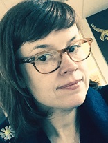 a photograph of Katherine. She is a 47 year old woman who is sitting in her office. She is smiling.
